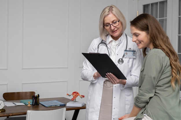 Foto grátis médico de tiro médio falando com paciente sorridente