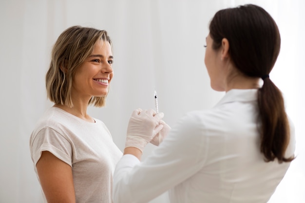 Médico de tiro médio segurando a seringa