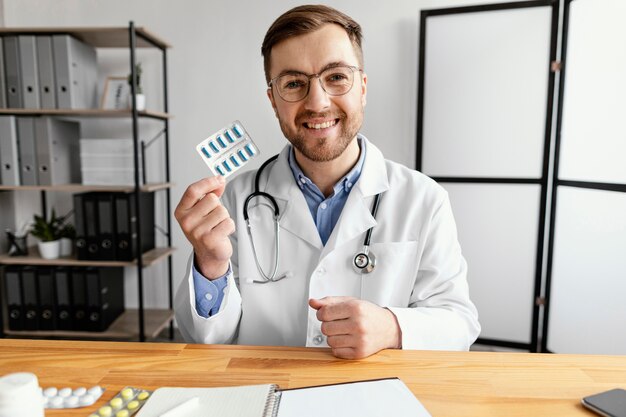 Médico de tiro médio segurando bolha de comprimidos