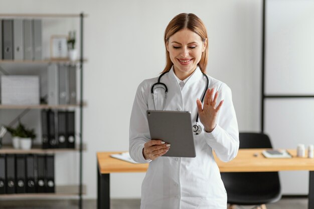 Médico de tiro médio segurando o tablet