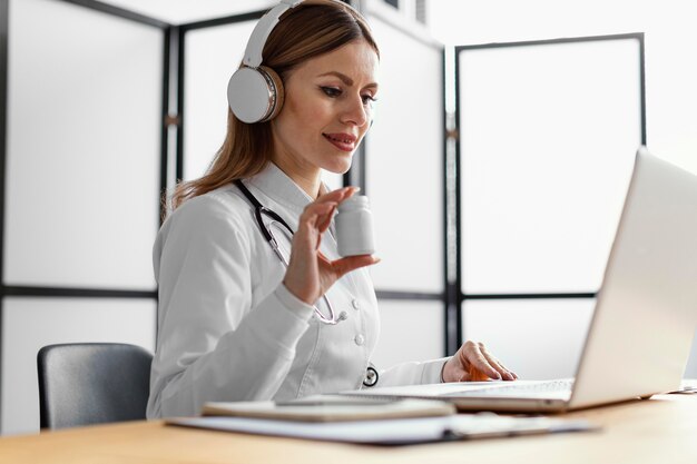 Médico de tiro médio trabalhando com laptop