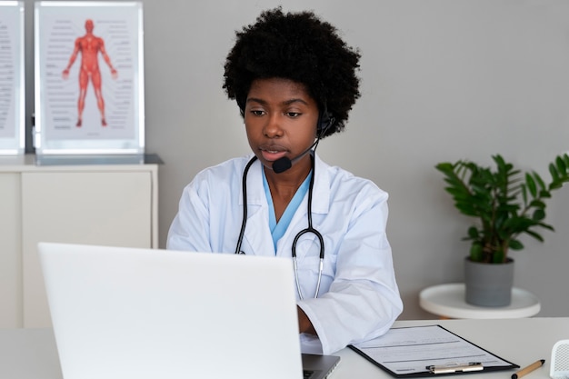 Foto grátis médico de tiro médio trabalhando com laptop