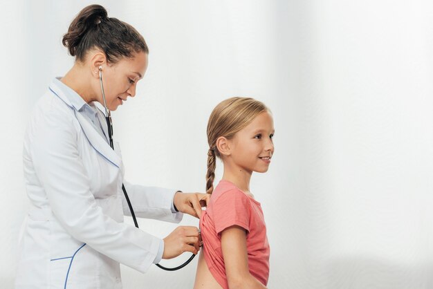 Médico de tiro médio verificando garota