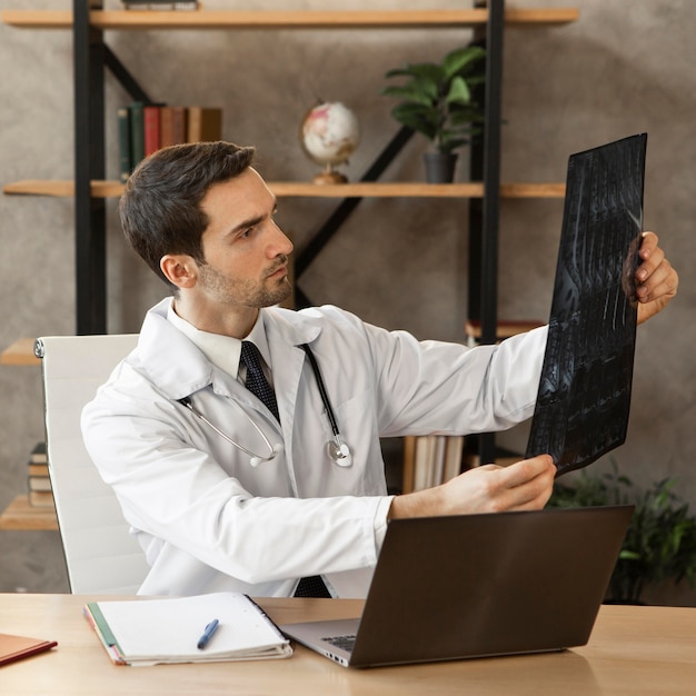 Foto grátis médico de tiro médio verificando radiografia