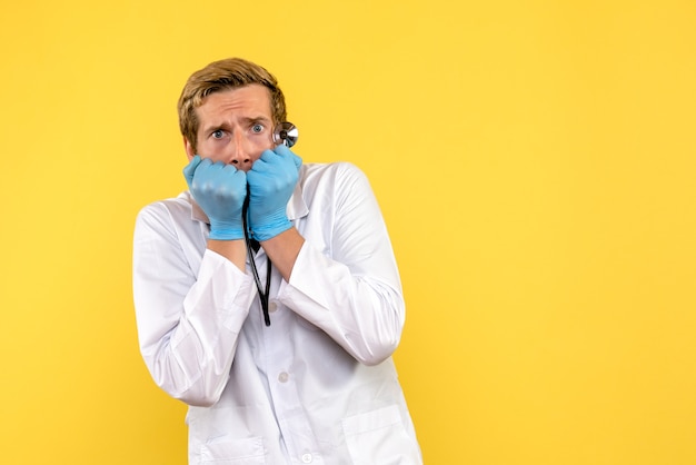 Médico de vista frontal com medo de fundo amarelo saúde humana vírus médico