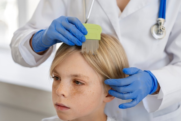 Foto grátis médico de vista lateral ajudando menino com piolhos