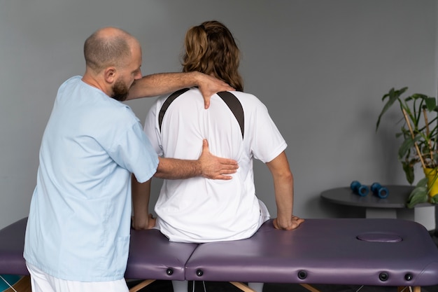 Foto grátis médico de vista traseira ajudando o paciente
