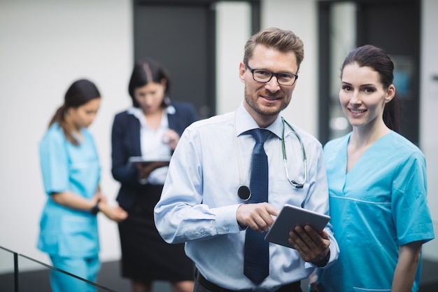 Médico e enfermeira sorrindo com tablet digital