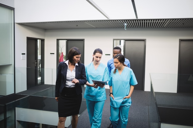 Médico e enfermeiras discutindo sobre tablet digital