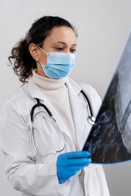 Médico em tiro médio olhando para uma radiografia