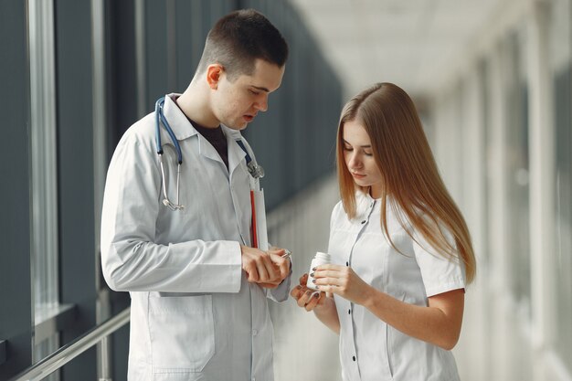 Médico está compartilhando pílulas nas mãos de outro médico