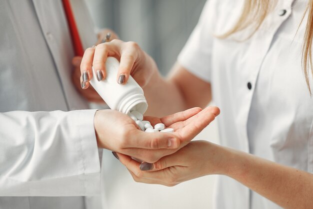Médico está compartilhando pílulas nas mãos de outro médico