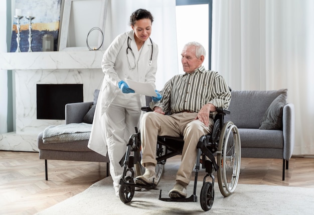 Médico falando com homem sênior dentro de casa