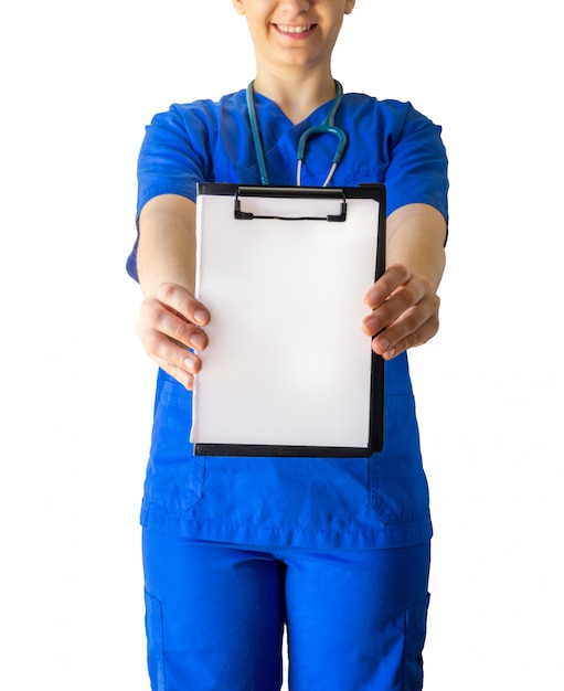Médico feminino alegre em um uniforme médico azul segurando um papel branco em branco, com um espaço de cópia