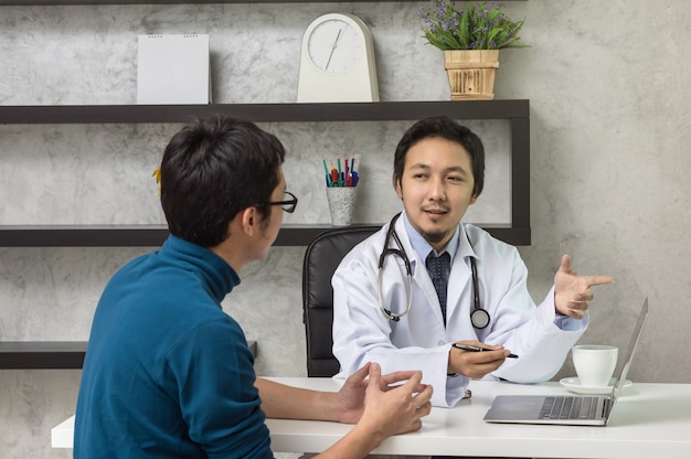 Médico masculino asiático, discutindo o diagnóstico com o paciente sobre sua saúde