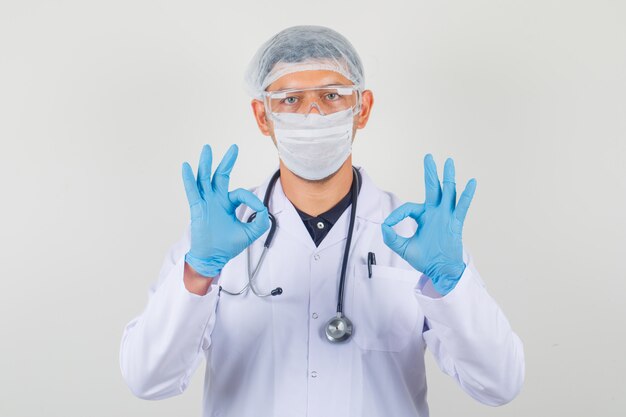 Médico masculino mostrando okey gesto em roupas de proteção.