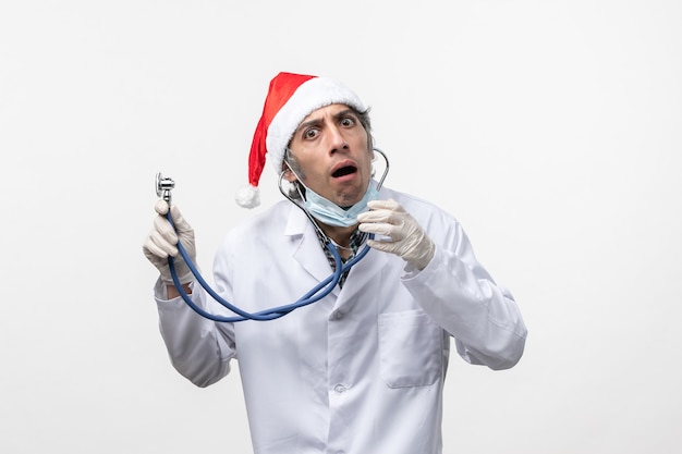 Médico masculino segurando um estetoscópio sobre o chão branco, vírus covida, emoção