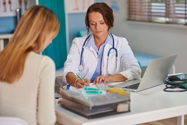 Médico prescrevendo uma receita para seu paciente