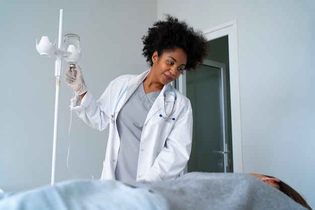 Foto grátis médico preto sorridente de baixo ângulo