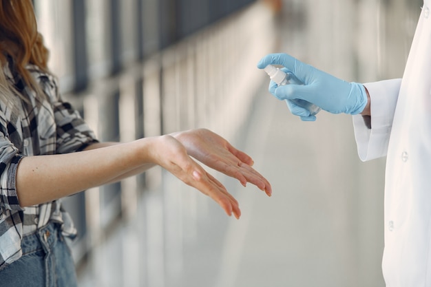 Médico pulveriza o anti-séptico nas mãos do paciente