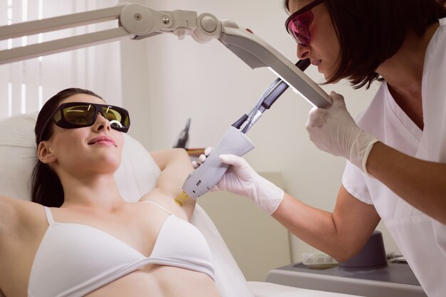 Médico realizando depilação a laser na pele do paciente