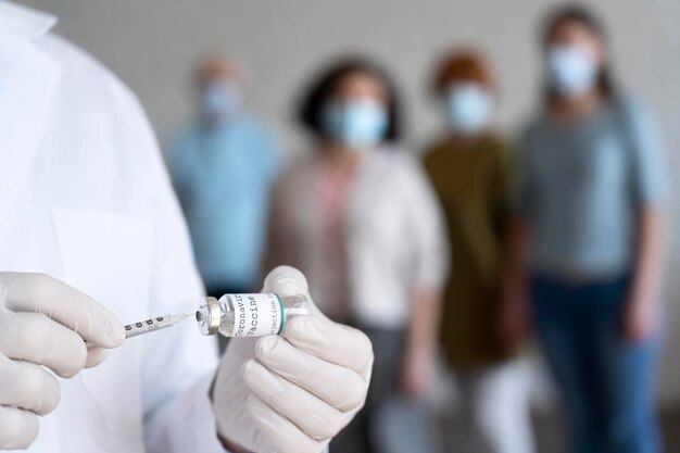 Médico segurando o frasco da vacina com seringa