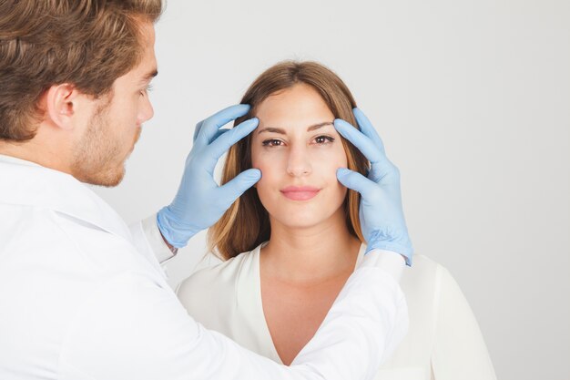 Médico segurando rosto de paciente