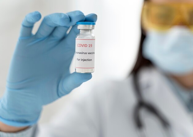 Médico segurando um close-up de recipiente de vacina