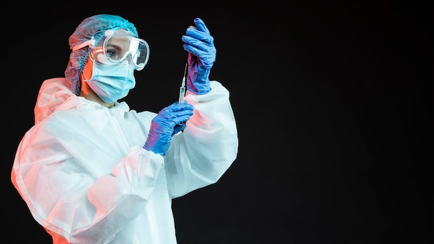 Médico segurando uma seringa com espaço de cópia