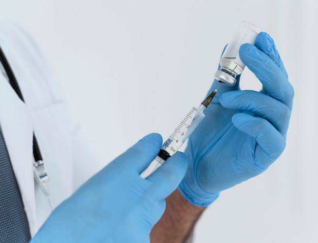 Foto grátis médico segurando uma seringa em close-up