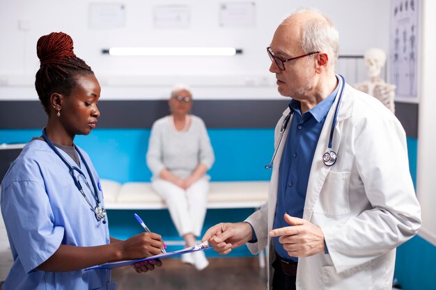 Médico sênior discute com enfermeira jovem