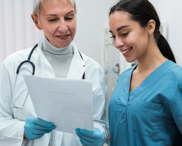 Médico sorridente conversando com uma enfermeira sorridente