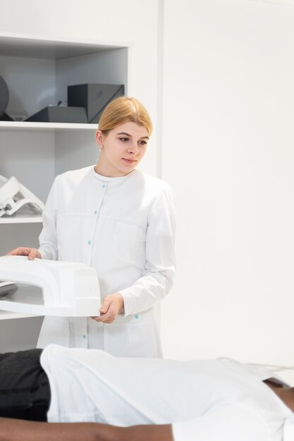 Médico sorridente dando tomografia computadorizada ao paciente