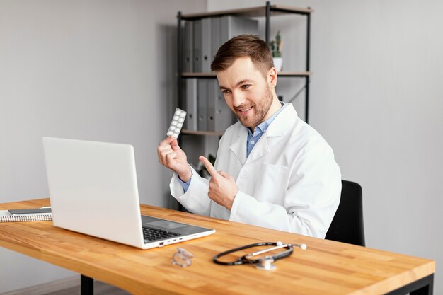 Médico sorridente de tiro médio na mesa