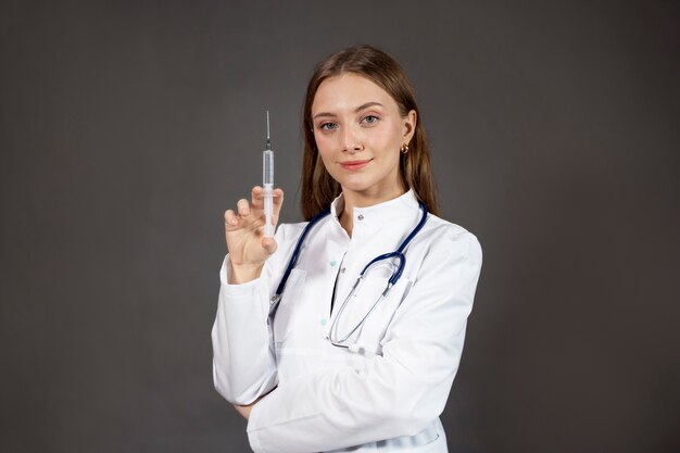 Médico sorridente de tiro médio segurando a seringa