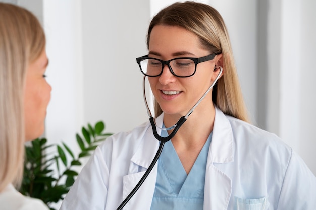 Foto grátis médico sorridente de vista frontal com estetoscópio