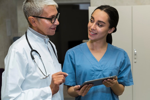 Médico sorridente e enfermeira conversando