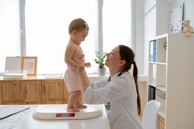 Médico sorridente segurando bebê tiro médio