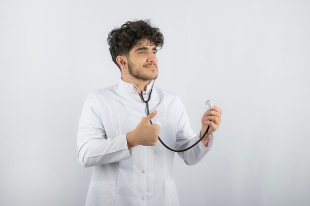 Médico sorridente segurando o estetoscópio e pronto para verificar o paciente.