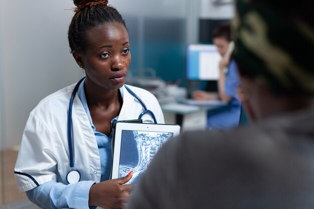 Médico terapeuta afro-americano segurando um tablet