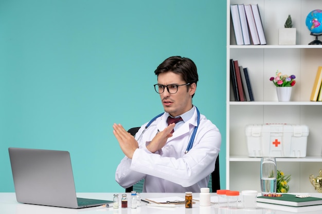 Foto grátis médico trabalhando no computador, médico inteligente e bonitinho remotamente sério no jaleco, interrompendo a chamada