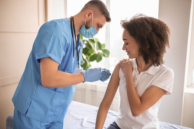 Médico vacinando um paciente em uma clínica
