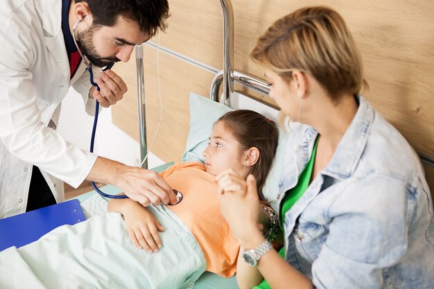 Médico verificando o coração do paciente no hospital