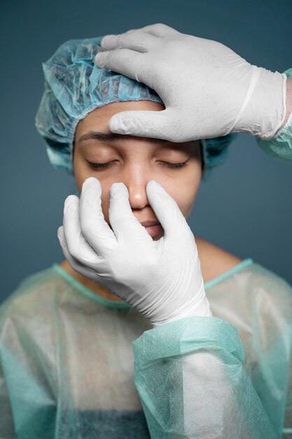 Médico verificando o nariz do paciente antes da cirurgia