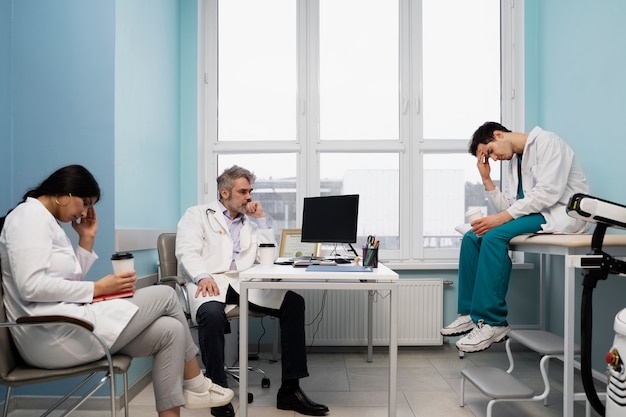 Foto grátis médicos de tiro completo sentados juntos