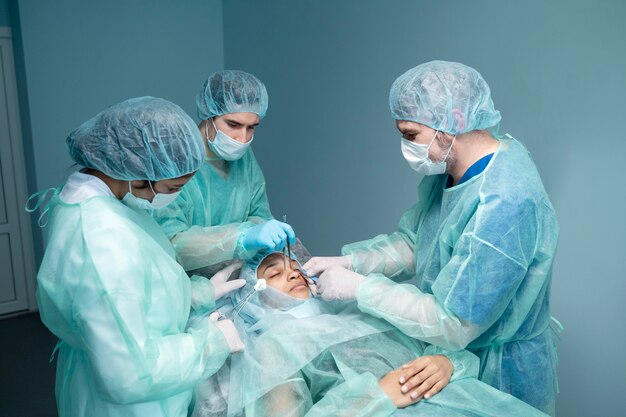 Médicos de tiro médio realizando rinoplastia