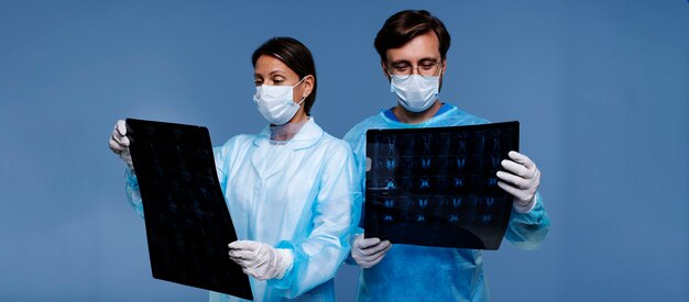 Médicos de vista frontal verificando radiografia