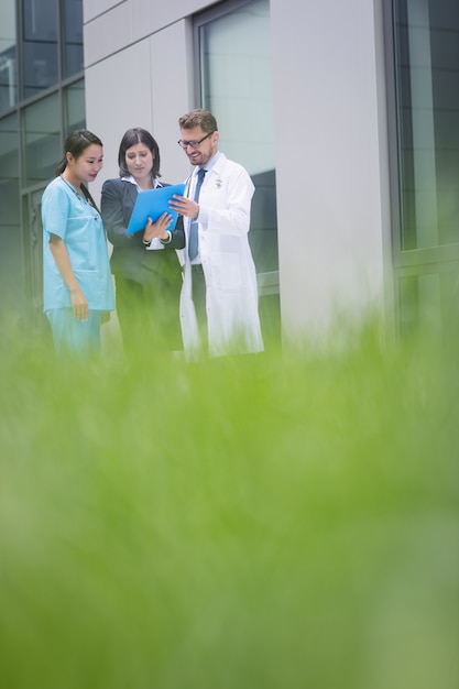 Médicos e enfermeira discutindo sobre o relatório