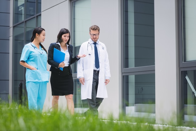 Médicos e enfermeiras interagindo enquanto caminham