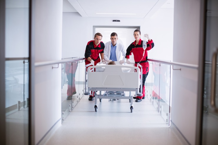 Foto grátis médicos empurrando cama maca de emergência no corredor